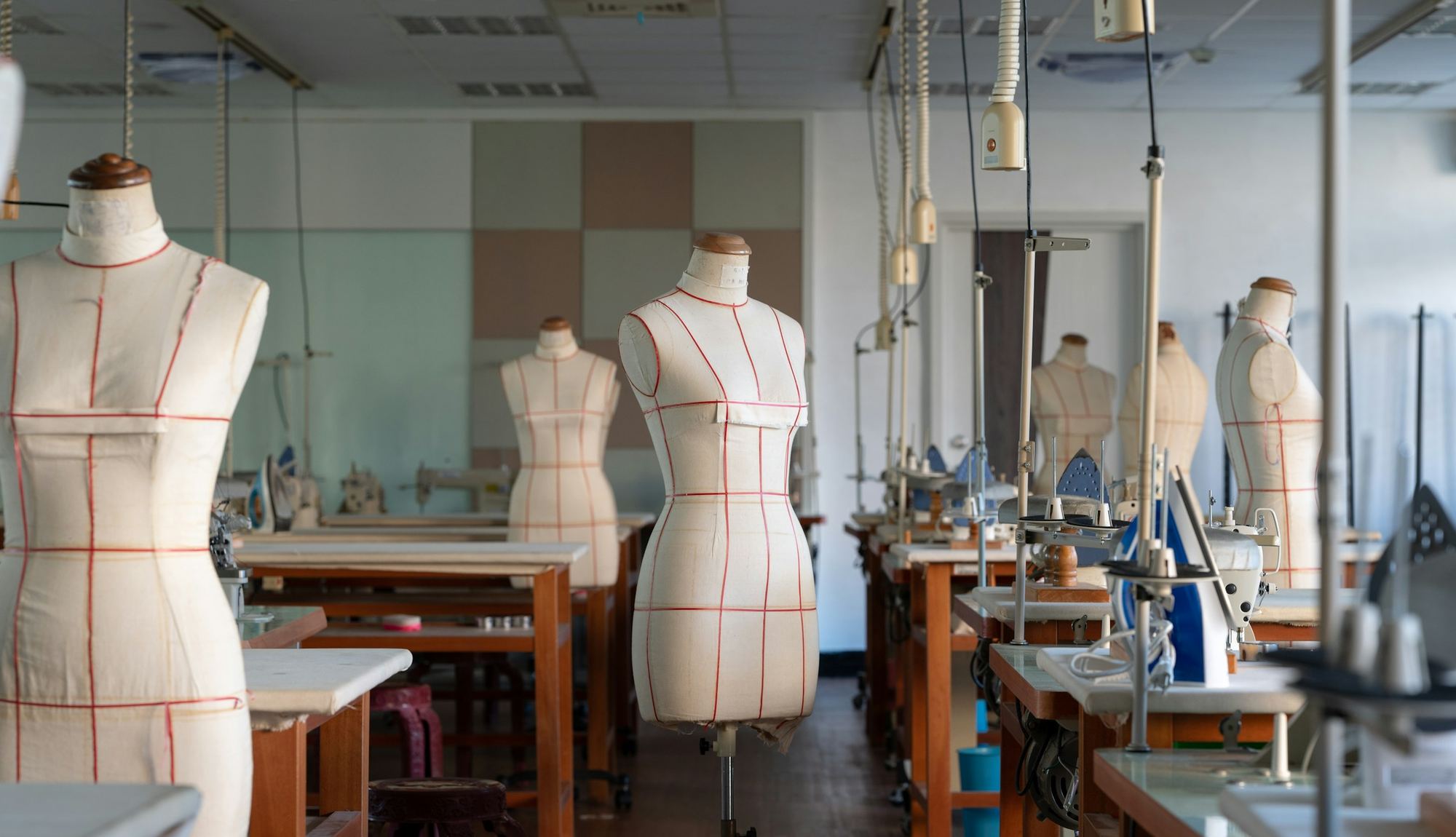 A garment workroom with dress forms and industrial sewing machines